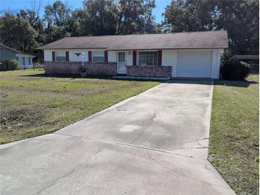 Brick ranch house with a large yard and long driveway at 2150 Ne 54Th St, Ocala, FL 34479