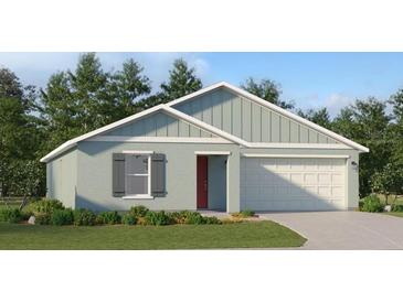 Single-story home with light teal siding, white garage door, and landscaping at 2882 Pennachio Dr, Lake Wales, FL 33859