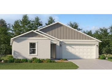 One-story home with gray siding, white garage door, and landscaped lawn at 2474 Mckinley Dr, Lake Wales, FL 33859