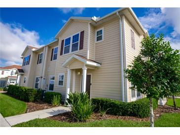 Tan three-story townhome with landscaping and walkway at 3231 Cupid Pl Pl, Kissimmee, FL 34747