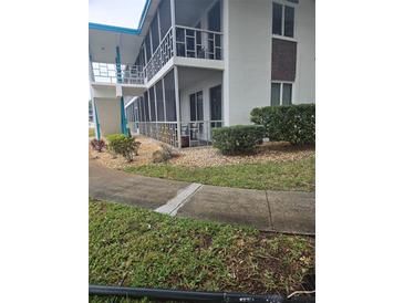 Low-rise building with manicured lawn, rock garden, and covered balconies with screened enclosures at 1600 W Lake Parker Dr # A6, Lakeland, FL 33805