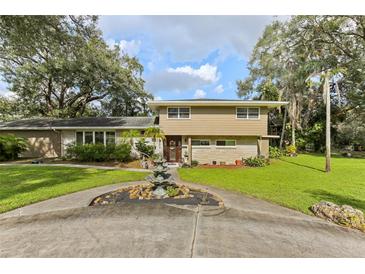 Two-story house with circular driveway, landscaping, and fountain at 1614 King James Ct, Lakeland, FL 33813