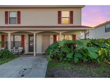 Tan two-story condo building with red-trimmed windows and lush landscaping at 980 Canal View Blvd # G1, Port Orange, FL 32129
