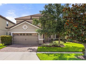Two-story house with a two-car garage and landscaped lawn at 1463 Myrtlewood St, Davenport, FL 33896