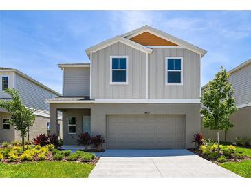 Two-story house with gray siding, orange accents, and a two-car garage at 4022 Gardenia Ave, Lake Hamilton, FL 33851