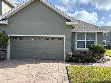 Grey house with attached two-car garage and brick driveway at 6528 Sedgeford Dr, Lakeland, FL 33811