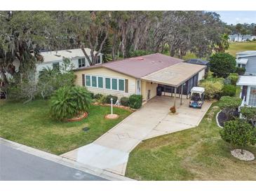 Aerial view of a single-Gathering home with golf course nearby at 1724 Magnolia Ave, Lady Lake, FL 32159