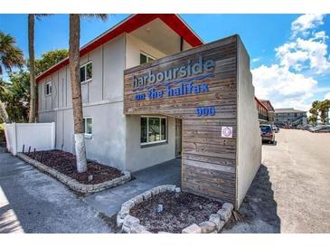Modern building exterior with parking and signage at 900 S Peninsula Dr # 102, Daytona Beach, FL 32118
