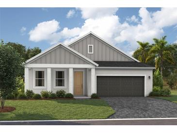 One-story home with gray siding, a two-car garage, and a landscaped lawn at 6201 Sw 97Th St, Ocala, FL 34476