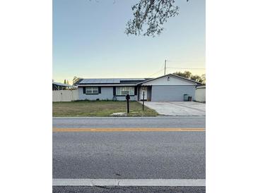 Ranch-style home with solar panels and landscaped lawn at 620 Lake Ned Rd, Winter Haven, FL 33884