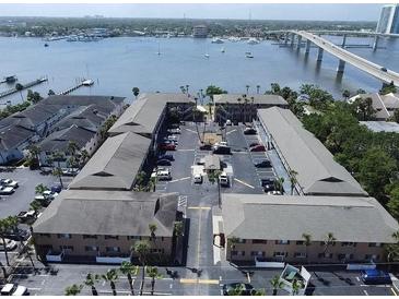 Aerial view of waterfront apartment building with parking and nearby bridge at 411 N Halifax Ave # 104, Daytona Beach, FL 32118