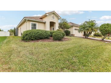 Stunning single-story home featuring a red tile roof, arched entryway and a lush, well-manicured front yard at 4026 Navigator Way, Kissimmee, FL 34746