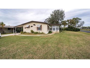 Single-wide mobile home with carport and landscaped lawn at 6055 Grand Oaks Se Dr, Winter Haven, FL 33884