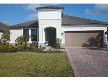 Charming single-Gathering home with well-maintained lawn, brick driveway, and neutral color palette at 621 San Augusto Dr, Poinciana, FL 34759
