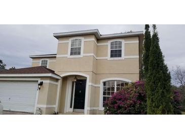 Two-story house with beige exterior, black door, and landscaping at 2938 Egrets Landing Dr, Lake Mary, FL 32746