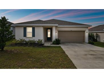 One-story house with a two-car garage and landscaped lawn at 1734 Hill Top Dr, Dundee, FL 33838