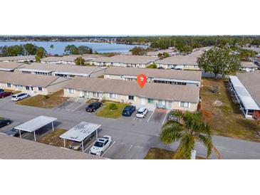 Aerial view of a condo community with a lake in the background at 260 Winter Ridge Blvd # 38, Winter Haven, FL 33881