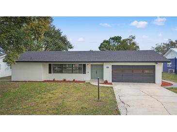 Ranch style home with gray garage and newly landscaped yard at 156 Whitman Rd, Winter Haven, FL 33884