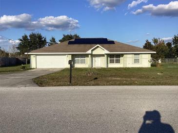 One-story house with solar panels, attached garage, and a well-maintained lawn at 63 Water Trak, Ocala, FL 34472