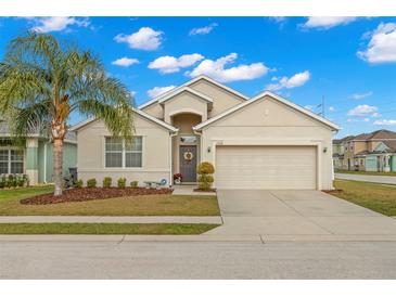 Tan one-story house with a two-car garage and palm tree at 1066 Krenson Woods Rd, Lakeland, FL 33813