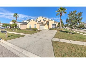 Charming two-story home featuring a well-maintained yard, palm trees, and a spacious driveway at 108 Emeraldview Ave, Davenport, FL 33897