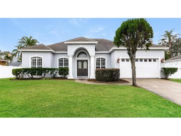 One-story home with gray exterior, white garage, and manicured lawn at 1046 Island Pointe Dr, Winter Garden, FL 34787