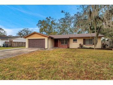 Brick ranch house with attached garage and well-maintained lawn at 5157 Black Birch Trl, Mulberry, FL 33860