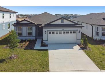 Charming single-story home with a manicured lawn, two car garage, and a concrete driveway at 1258 Lakeridge Way, Lake Alfred, FL 33850