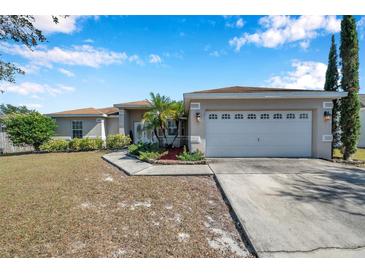 Single-story home with a two-car garage and landscaped yard at 1371 Laurel Glen Dr, Bartow, FL 33830