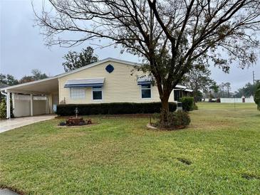 Yellow single story home with carport and landscaped lawn at 3109 Sand Trap Ct, Lakeland, FL 33810