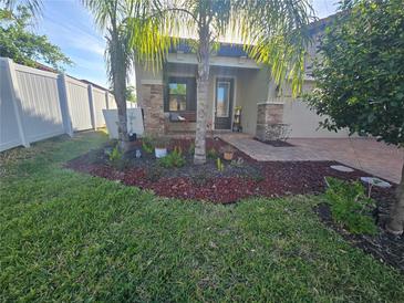 Charming home featuring beautiful landscaping, palm trees, and a quaint front porch swing at 4035 Solamor St, Lakeland, FL 33810
