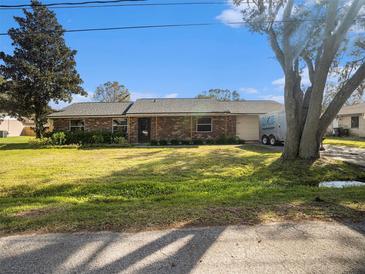 Charming single-story brick home featuring a well-maintained lawn and mature shade trees at 5040 Kirkland Rd, Lakeland, FL 33811
