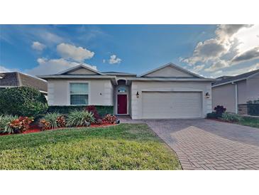 One-story home with red door, brick driveway, and landscaped lawn at 3537 Raleigh Dr, Winter Haven, FL 33884