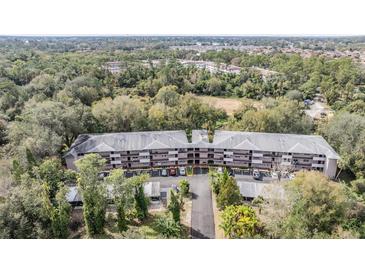 Aerial view of a condo building with ample parking and lush landscaping at 150 El Dorado # 101, Winter Haven, FL 33884