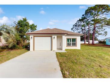 Newly constructed single story home with attached garage and well-manicured lawn at 223 Stanley Ave, Frostproof, FL 33843
