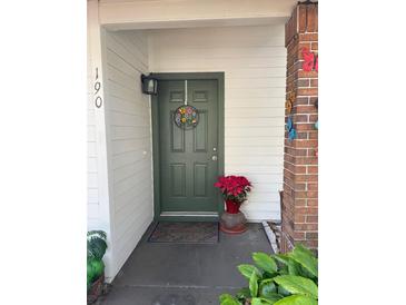 Inviting front entrance with green door, welcome wreath, and charming decor creates a warm, welcoming feel at 190 Post Way, Casselberry, FL 32707