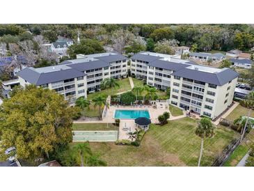 Aerial view of a condo community featuring a pool, shuffleboard, and lush landscaping at 101 N Grandview St # 312, Mount Dora, FL 32757