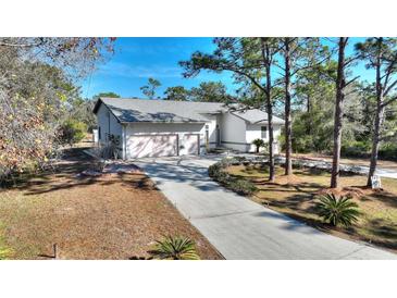 Single-story home with attached two-car garage and long driveway at 3060 Granada Dr, Indian Lake Estates, FL 33855