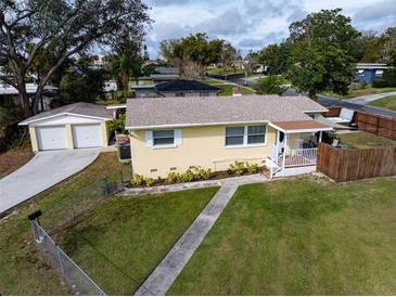 Cute yellow house with detached garage, fenced yard, and hot tub at 228 Azalea St, Lakeland, FL 33803