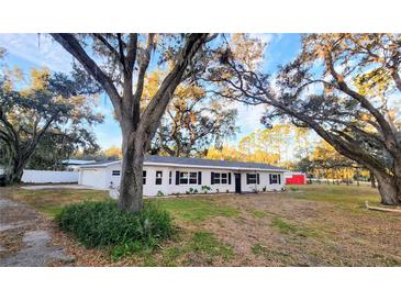 Newly renovated home with a white exterior, black windows, and landscaping at 3720 Willis Rd, Mulberry, FL 33860