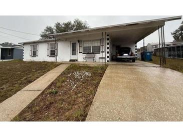 Ranch style home with carport and mature landscaping at 1106 Avenue N, Haines City, FL 33844