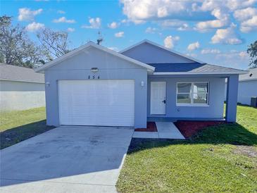 Charming single-story home with a well-maintained lawn, attached garage, and a beautifully painted exterior at 854 4Th St, Winter Haven, FL 33881