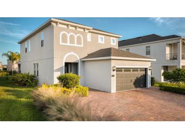 Two-story house with attached garage and landscaped front yard at 7705 Fairfax Dr, Kissimmee, FL 34747