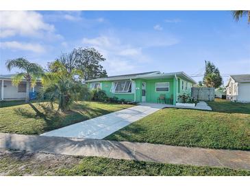 Charming single-story green home with a well-manicured lawn and a concrete driveway leading to the entrance at 38 Seaside Dr, Ormond Beach, FL 32176