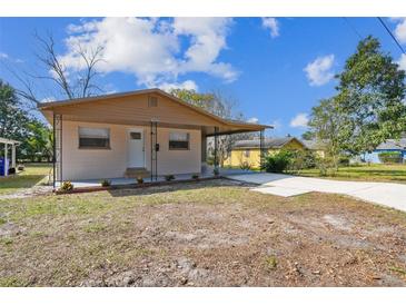 Charming single-story home featuring a large covered driveway, manicured landscape, and a cozy front entrance at 1422 Connestee Rd, Lakeland, FL 33805