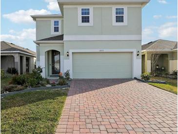 Charming two-story home featuring a brick driveway and attached two-car garage at 6973 Wilson Pasture Ave, Groveland, FL 34736