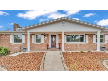 Charming brick home featuring a welcoming front porch and manicured landscaping at 3603 Royal S Ct, Lakeland, FL 33812