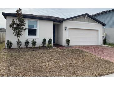 Charming single-Gathering home featuring a two-car garage and landscaped front yard at 145 Andreas St, Winter Haven, FL 33881