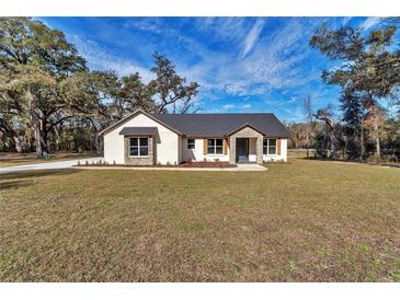 Charming single-story home with a well-manicured lawn and stone accents at 7 Hill Prince Dr, Ocala, FL 34482