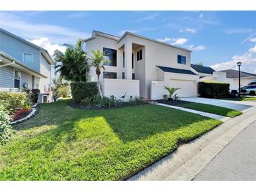 Modern two-story home with manicured lawn and tropical landscaping at 616 Peninsular Dr, Lakeland, FL 33813
